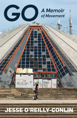 A book cover with a photo of a large triangular building, covered in graffiti. There is a man standing in front of it, but he looks small because the photo was taken from far away.